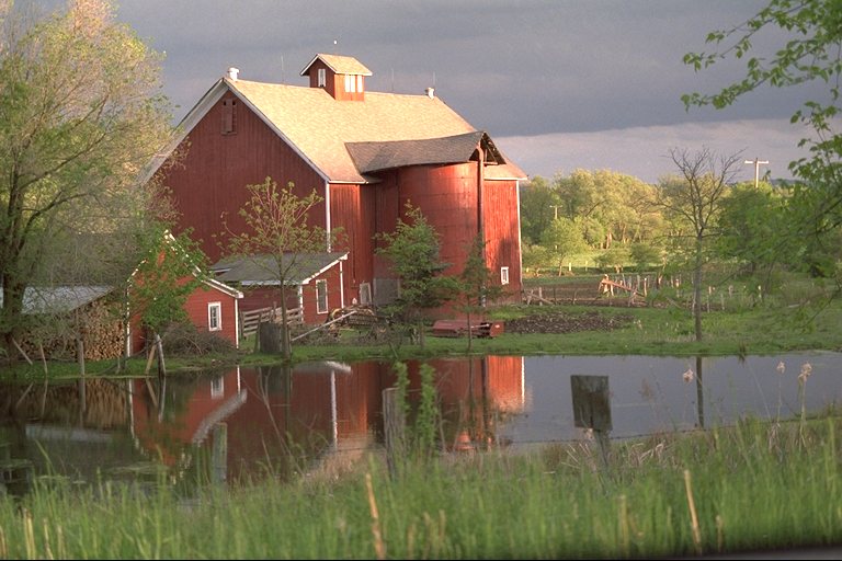 A red barn reflected in a pond